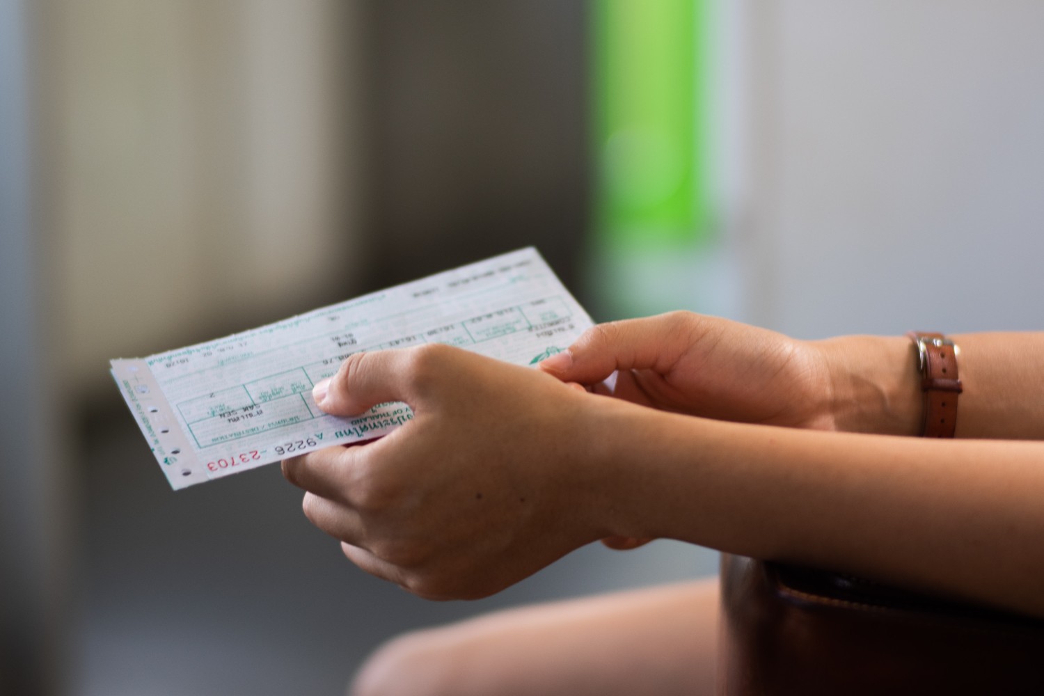 Hands holding a Greyhound bus ticket