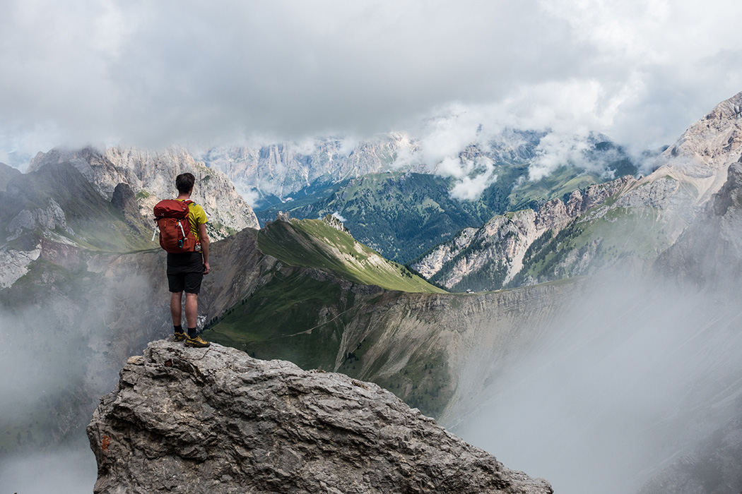 Photo of a hiker looking out at a beautiful mountain range.