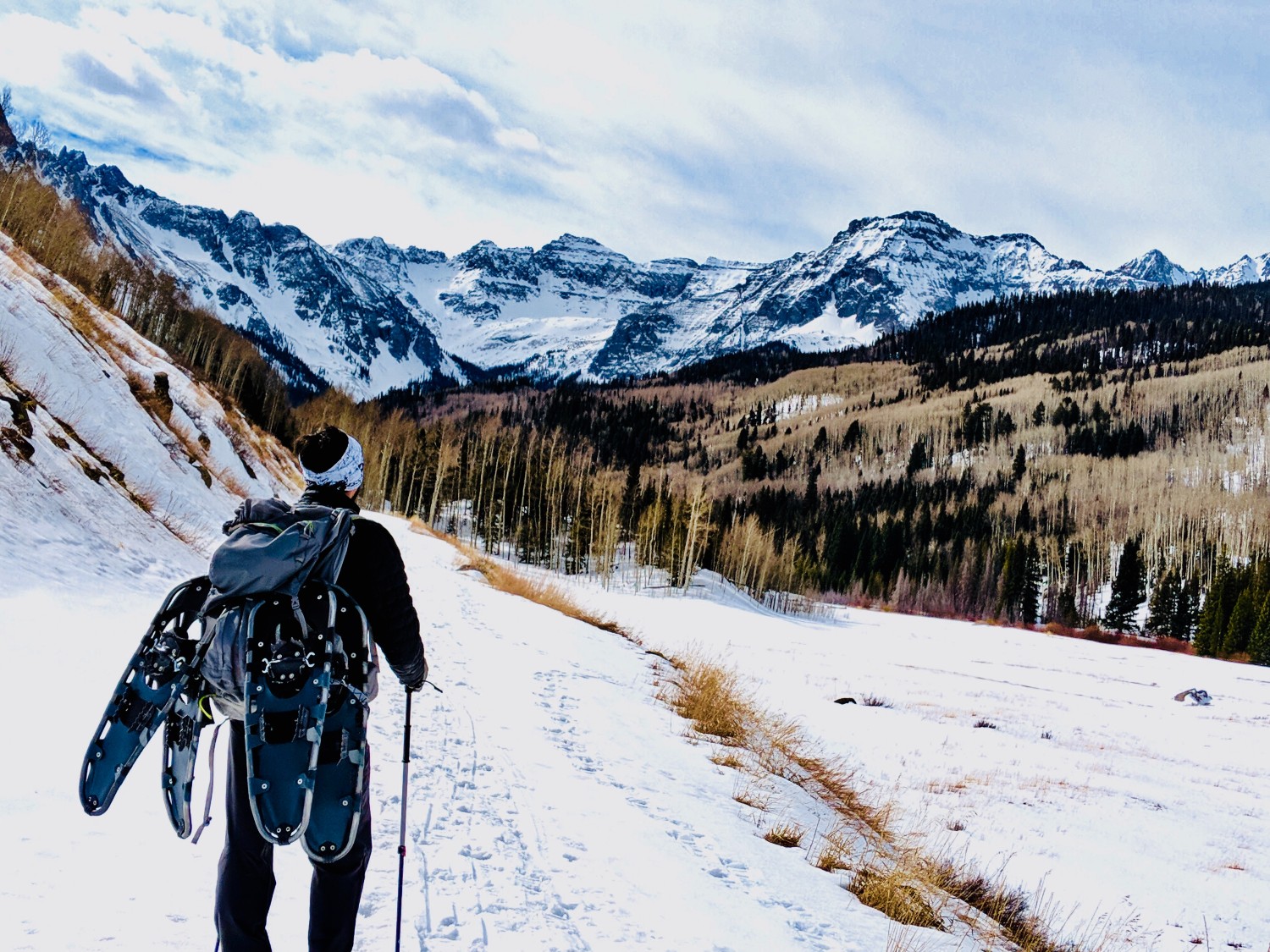 A snowshoer gazes upon snowy mountains in Colorado