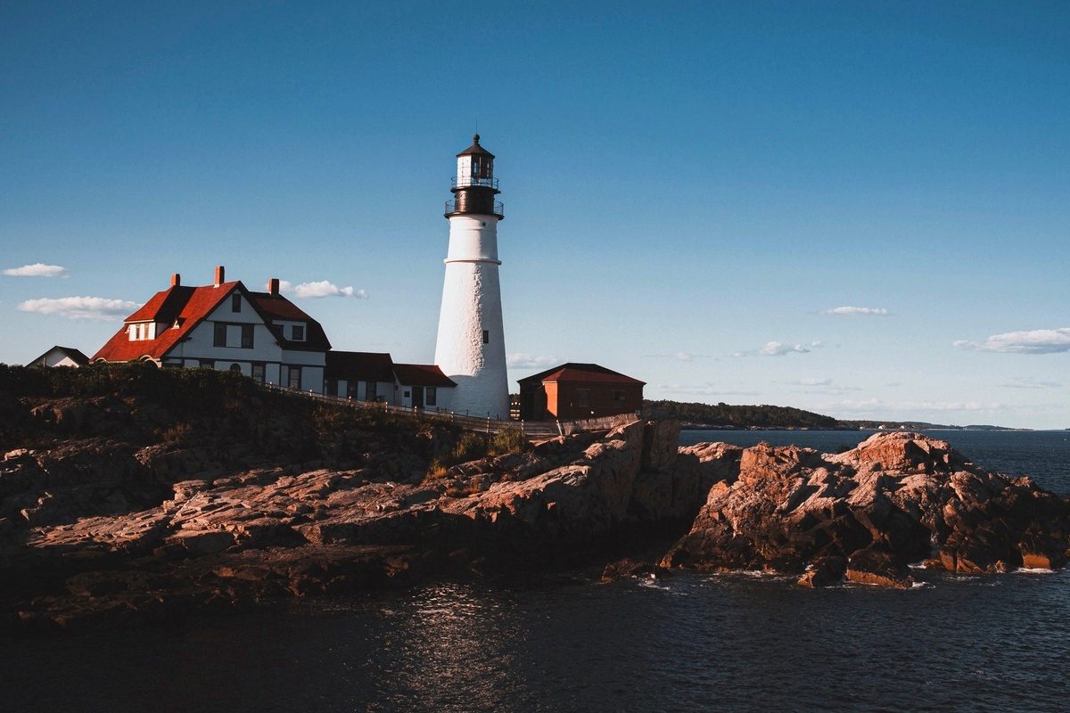 Portland Head Light at dusk, the keeper’s house in the foreground and the lighthouse on the rocks behind it