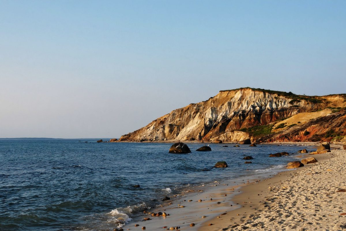 The banded clay cliffs at Aquinnah on the western tip of Martha’s Vineyard, above a sandy beach with boulders in the shallows