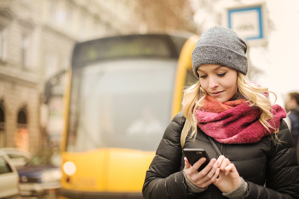 Photo of a woman about to board a bus with her mobile boarding pass.