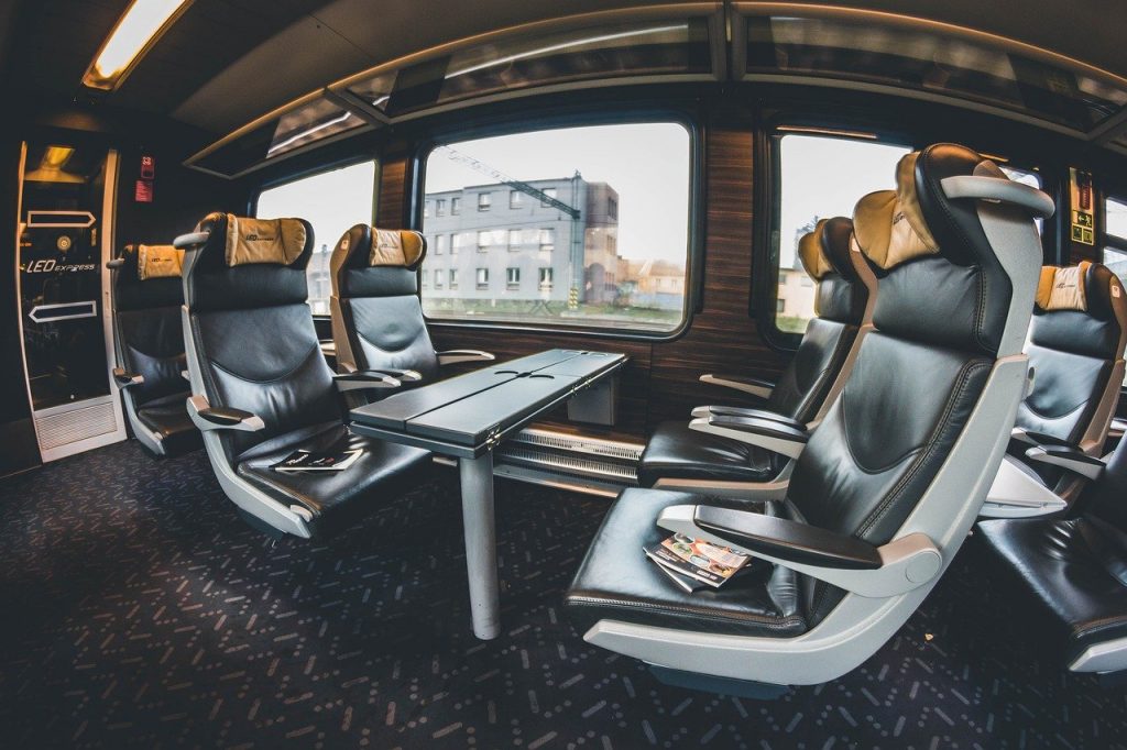 Photo inside a train that's filled with amenities like leather seats and extra legroom.
