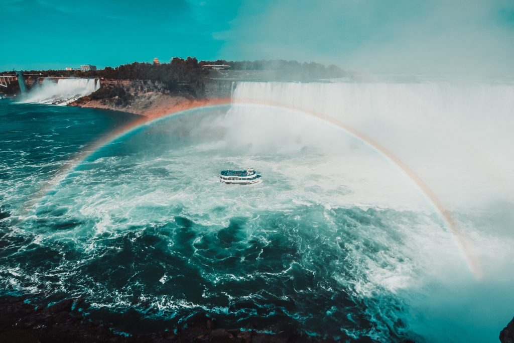 A rainbow forms over the Maid of the Mist boat