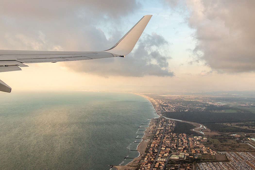 The view through a plane window as the aircraft ascends into the clouds.