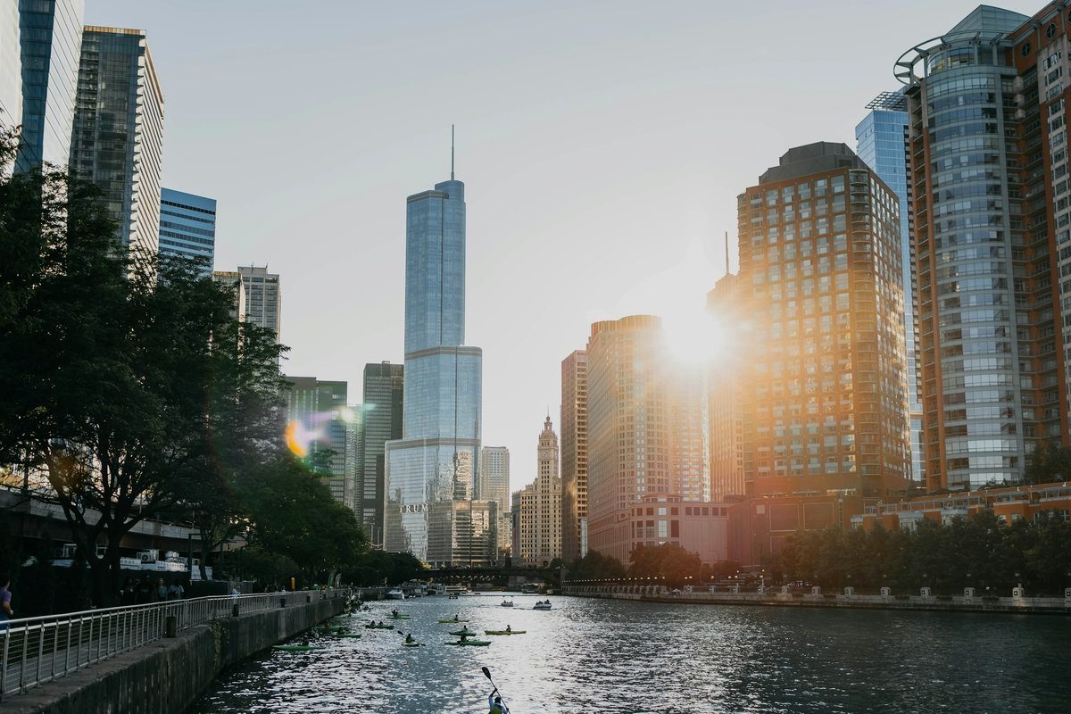 Kayakers on the Chicago River between the skyscrapers of the Loop at golden hour