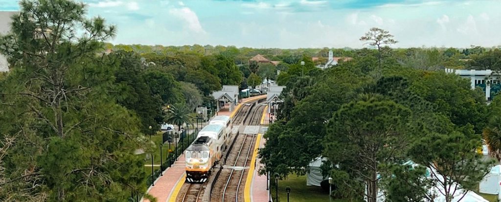 A train runs between lush trees on a Florida railroad