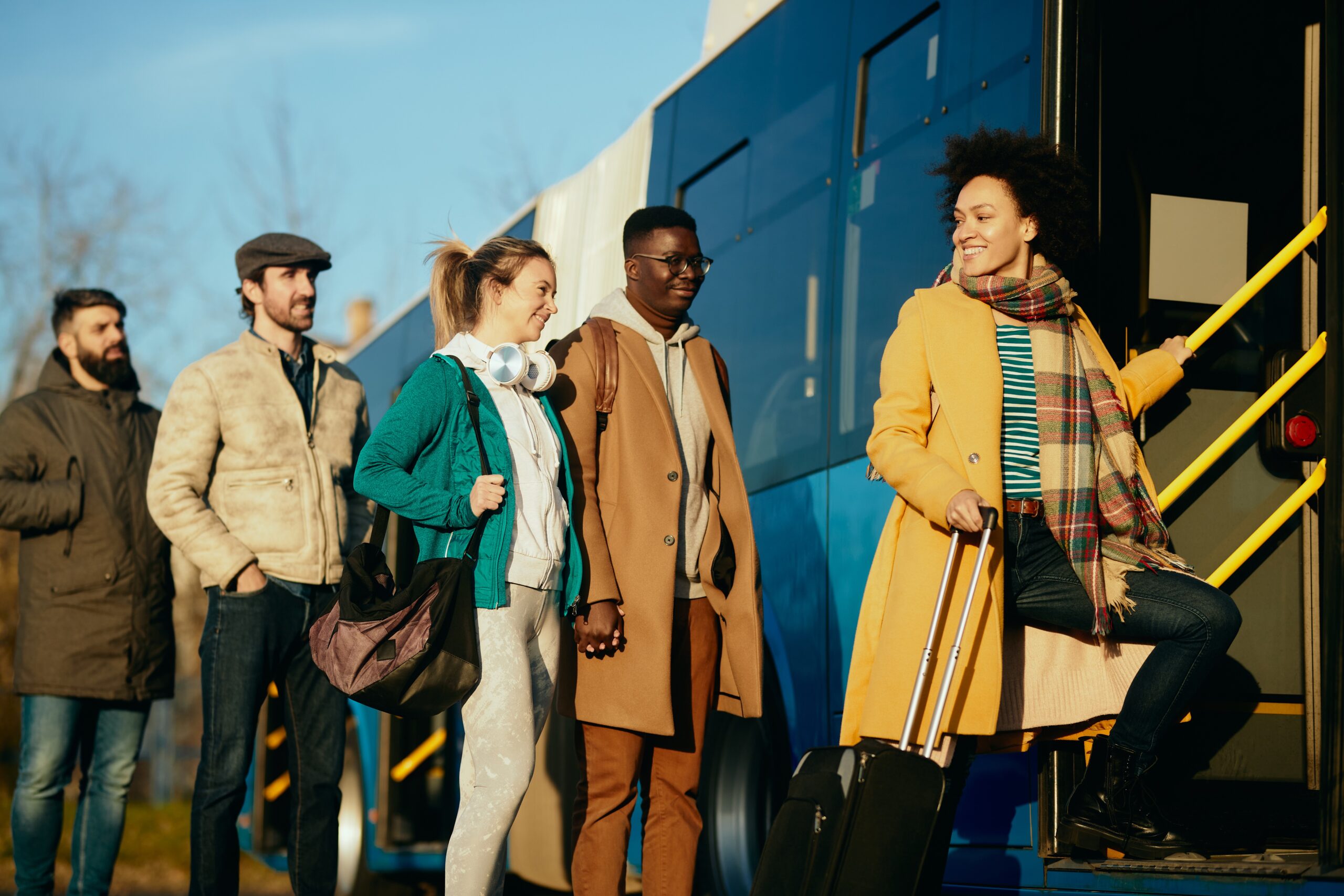 Happy passengers boarding a bus home for the holidays - Wanderu