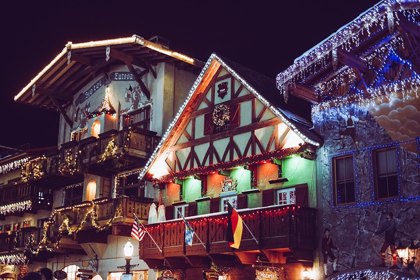 German-style lodges adorned with bright Christmas lights at night
