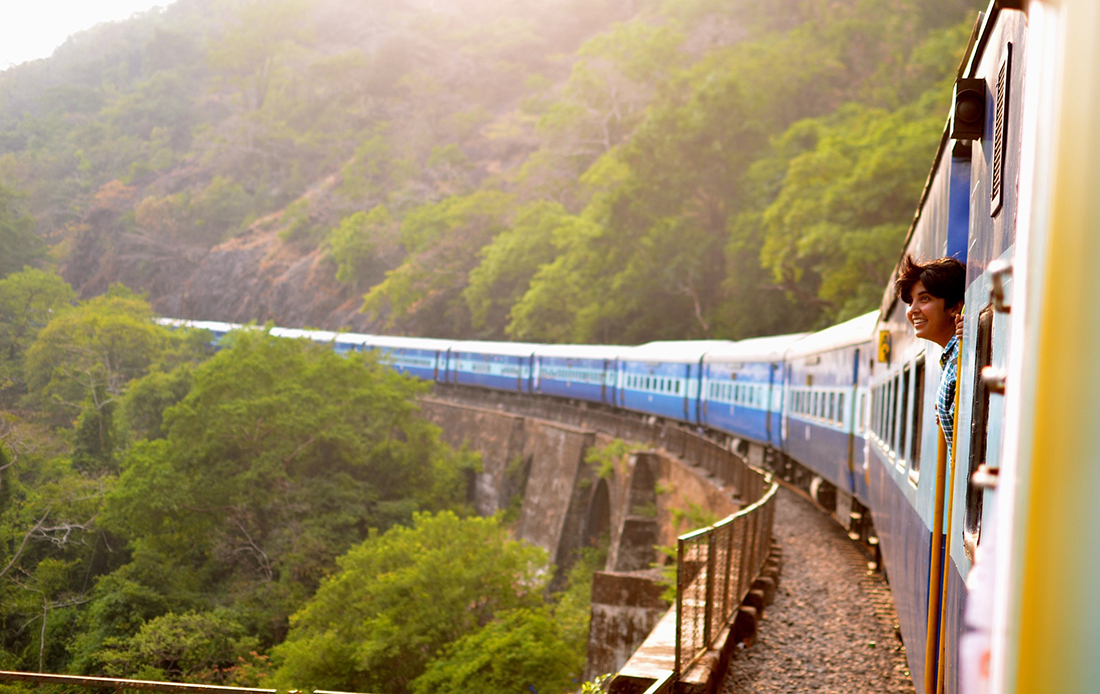Photo of a happy passenger peering out of a train.