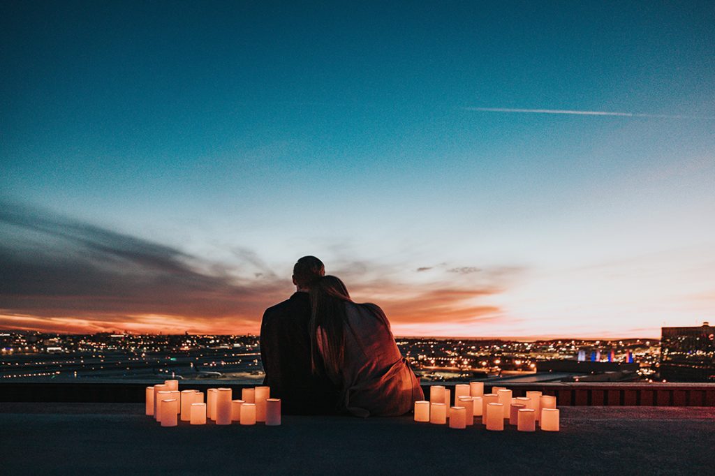 A couple gazing out at a beautiful sunset.