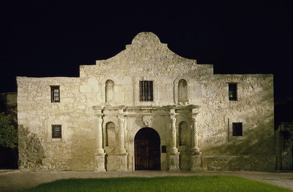 Photo of the famous Alamo mission at night.
