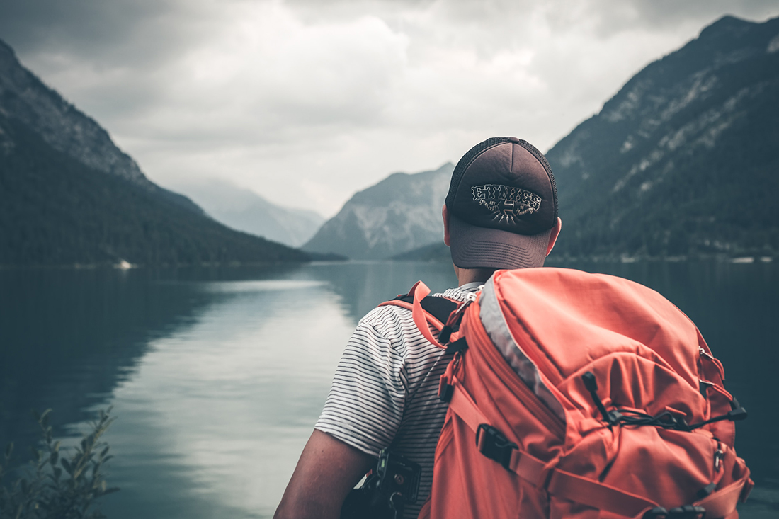 Solo traveler gazing out at a lake.