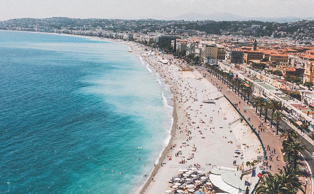 Photo of a crowded beach on a sunny day in Nice.