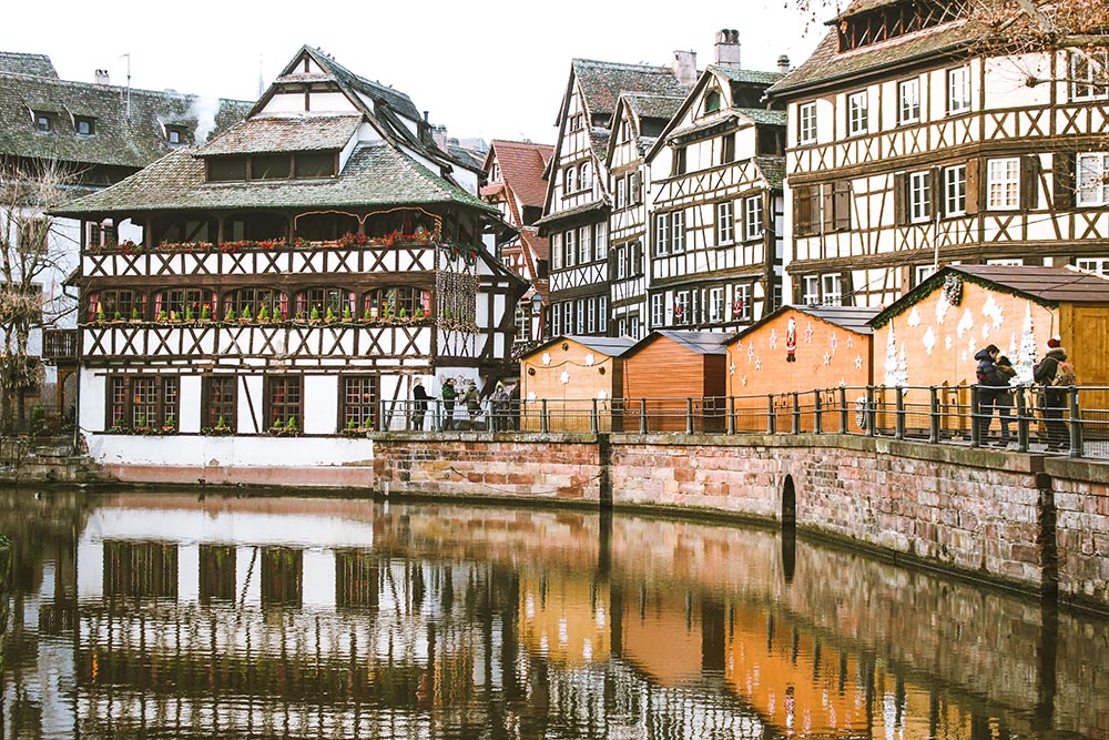 Photo of a canal in Strasbourg, with some buildings that show French/German influence.