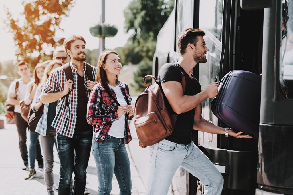 A group of travelers with trip protection board a bus.